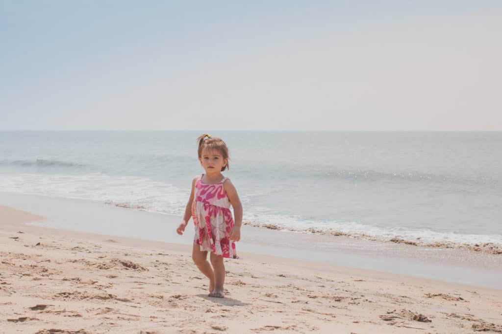 Toddler walks along a beach in Kashmir