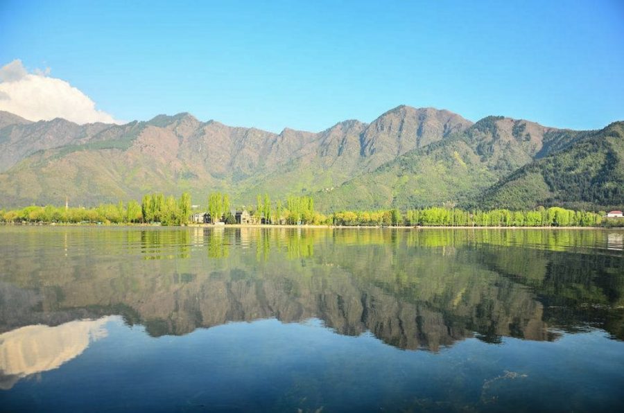 Lake in Kashmir is shown with a reflection of the mountains on the water