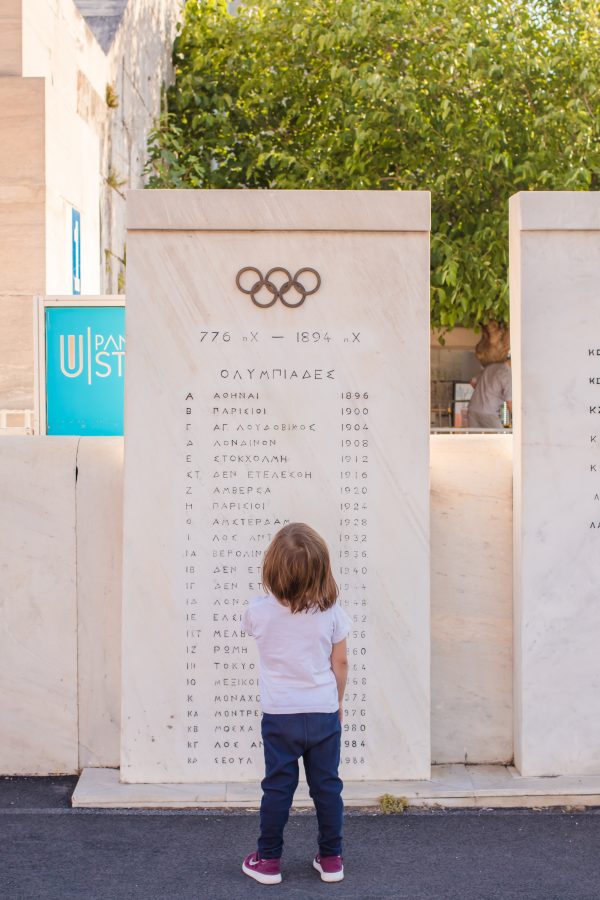 Small girl trys to read the Olympic sign in Athens